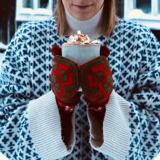 Vinterklädd tjej håller i varm choklad