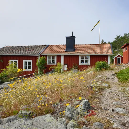 Rött hus i kuperat landskap